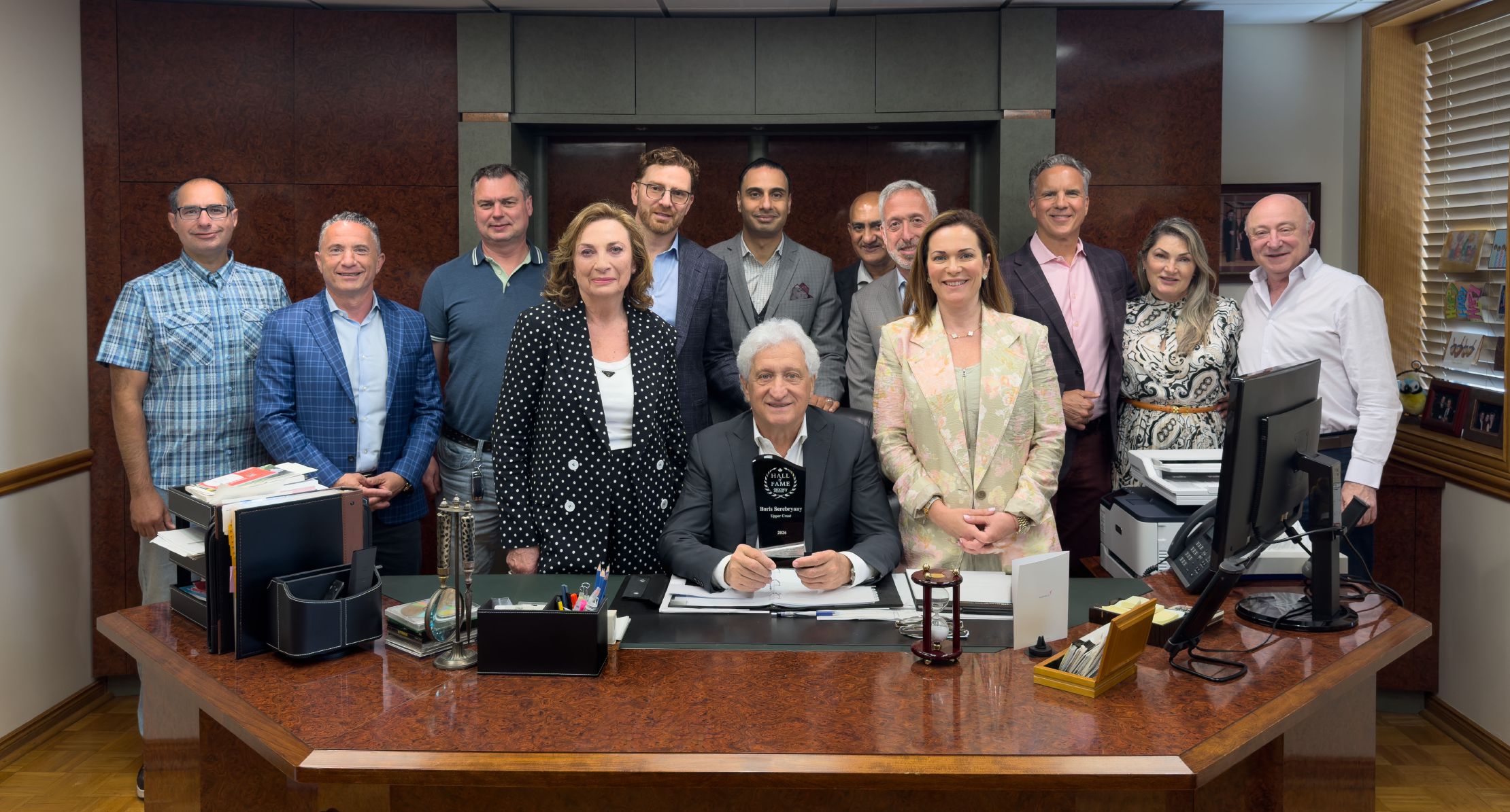 Boris Serebryany holding Grocery Business Lifetime Achievement Award surrounded by team members